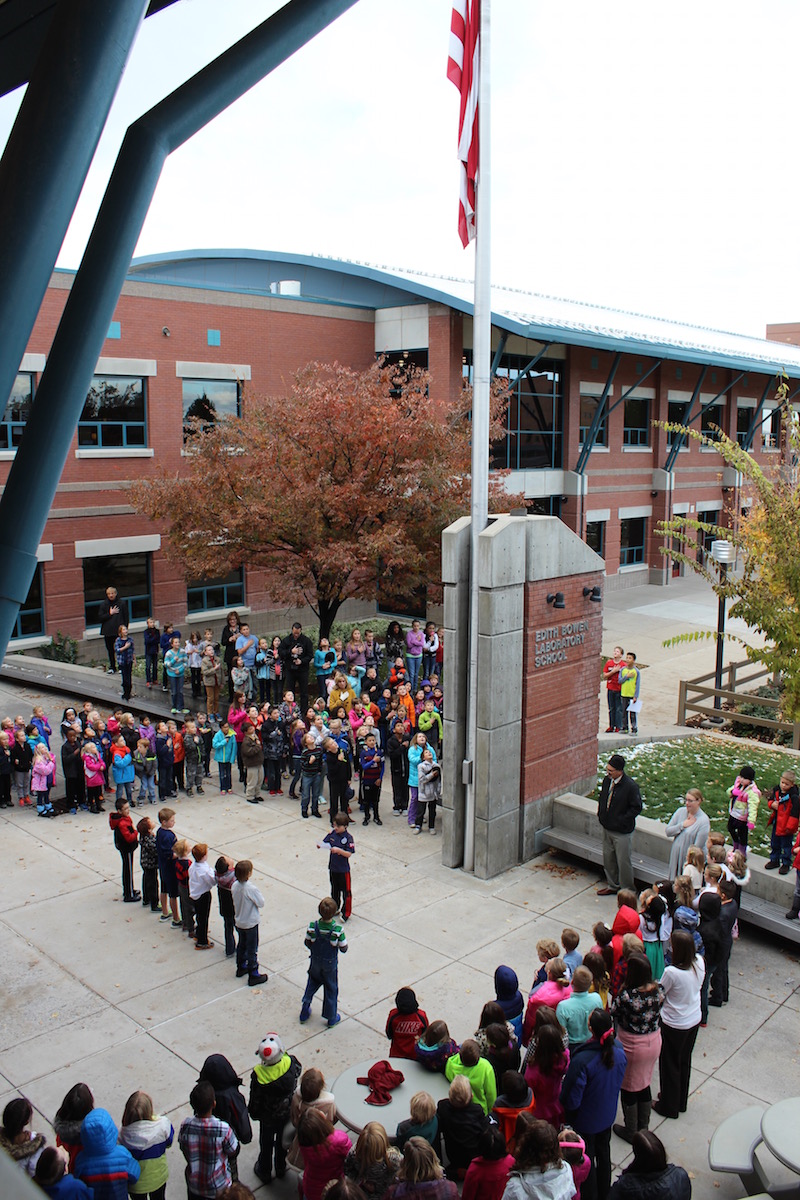 EBLS students reciting the Pledge of Allegiance around the outside flag pole. 