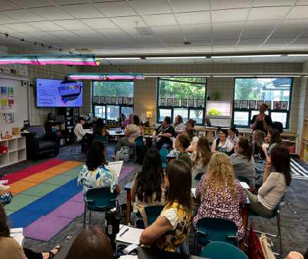 A large group of teachers listening to a presentation.