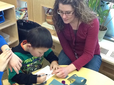 Woman teaching toddler to draw