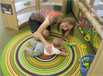 Woman helping baby with tummy time