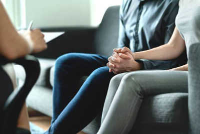 Couple holding hands while talking to a counselor