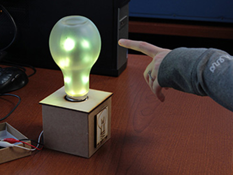 person pointing at desk light