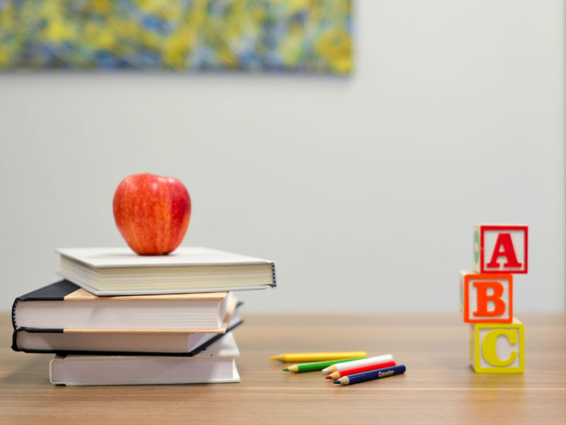 desk with books stacked and other teaching materials