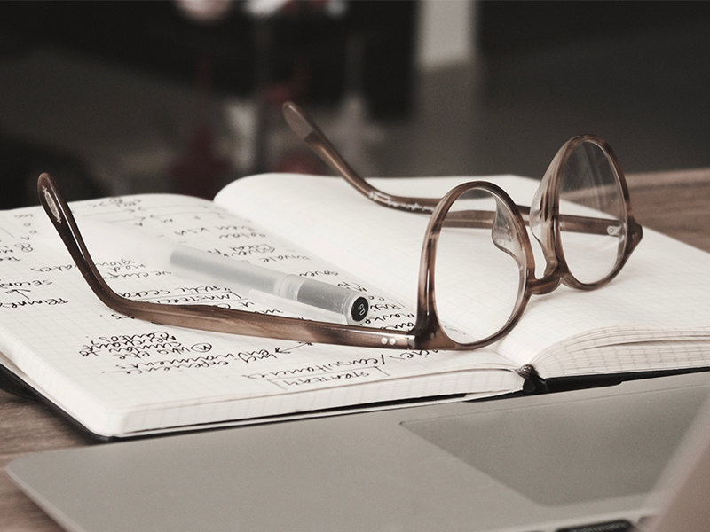 glasses lying on top of an open notebook