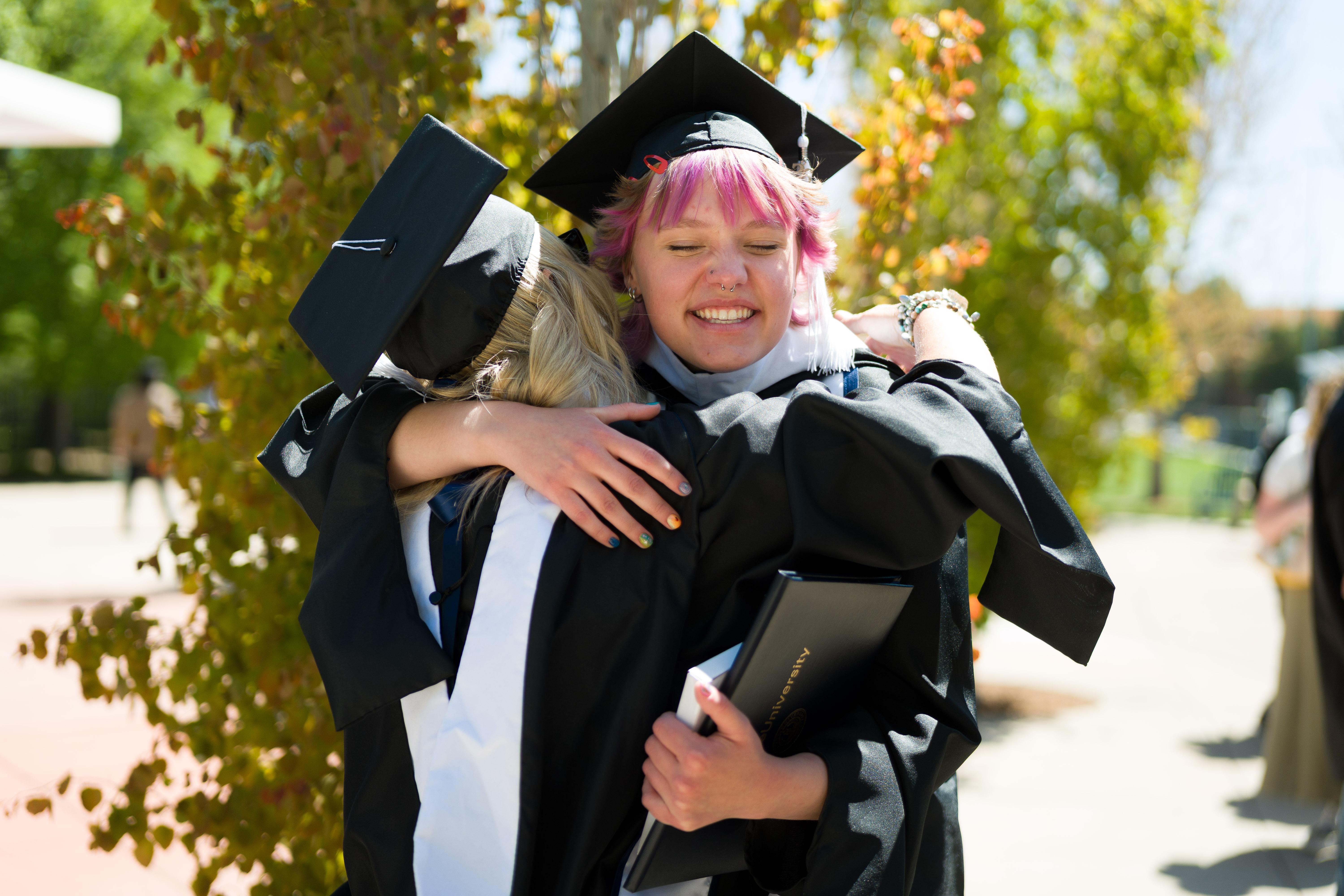 graduates embracing after the ceremony