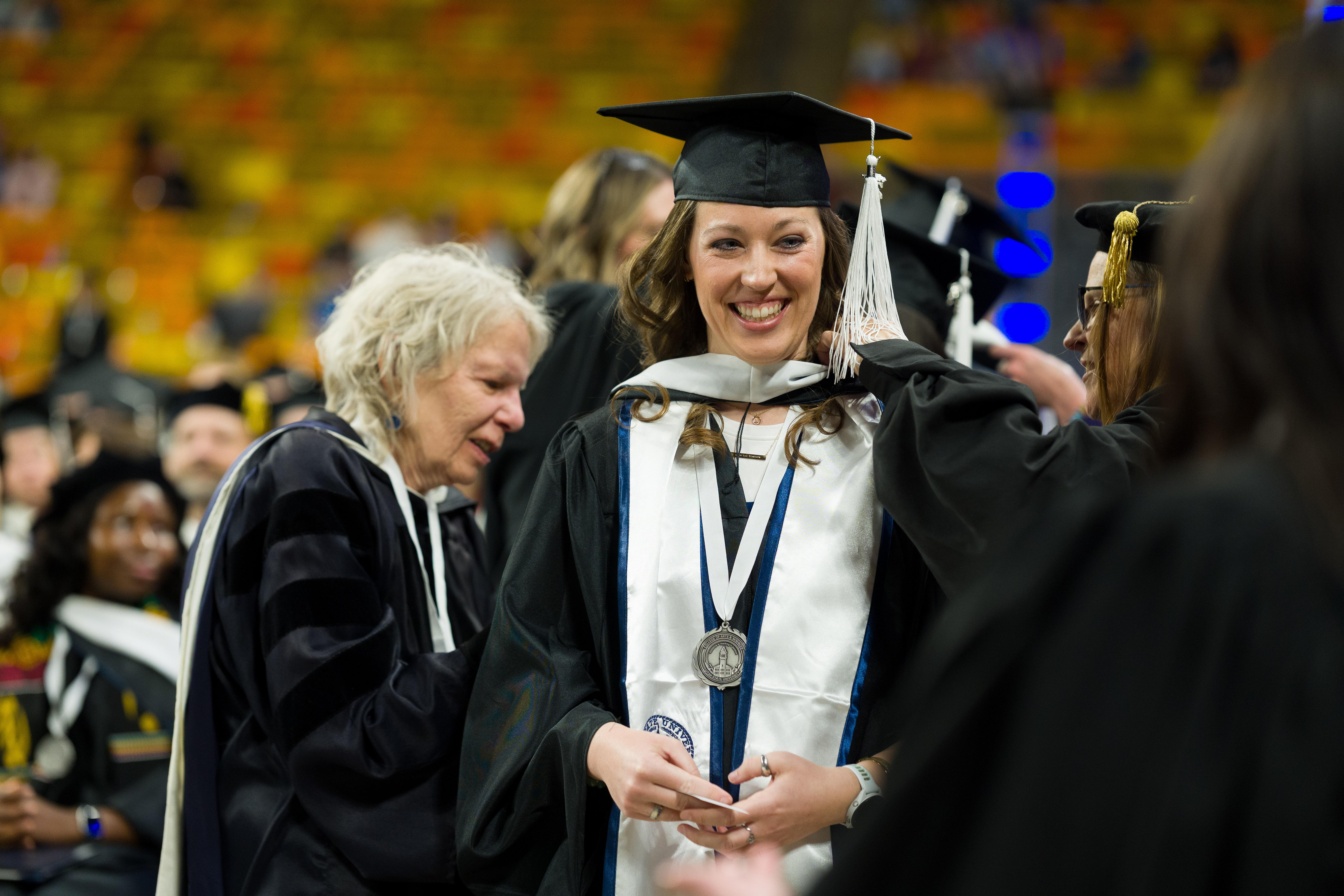 graduates receiving handshakes from college personnel