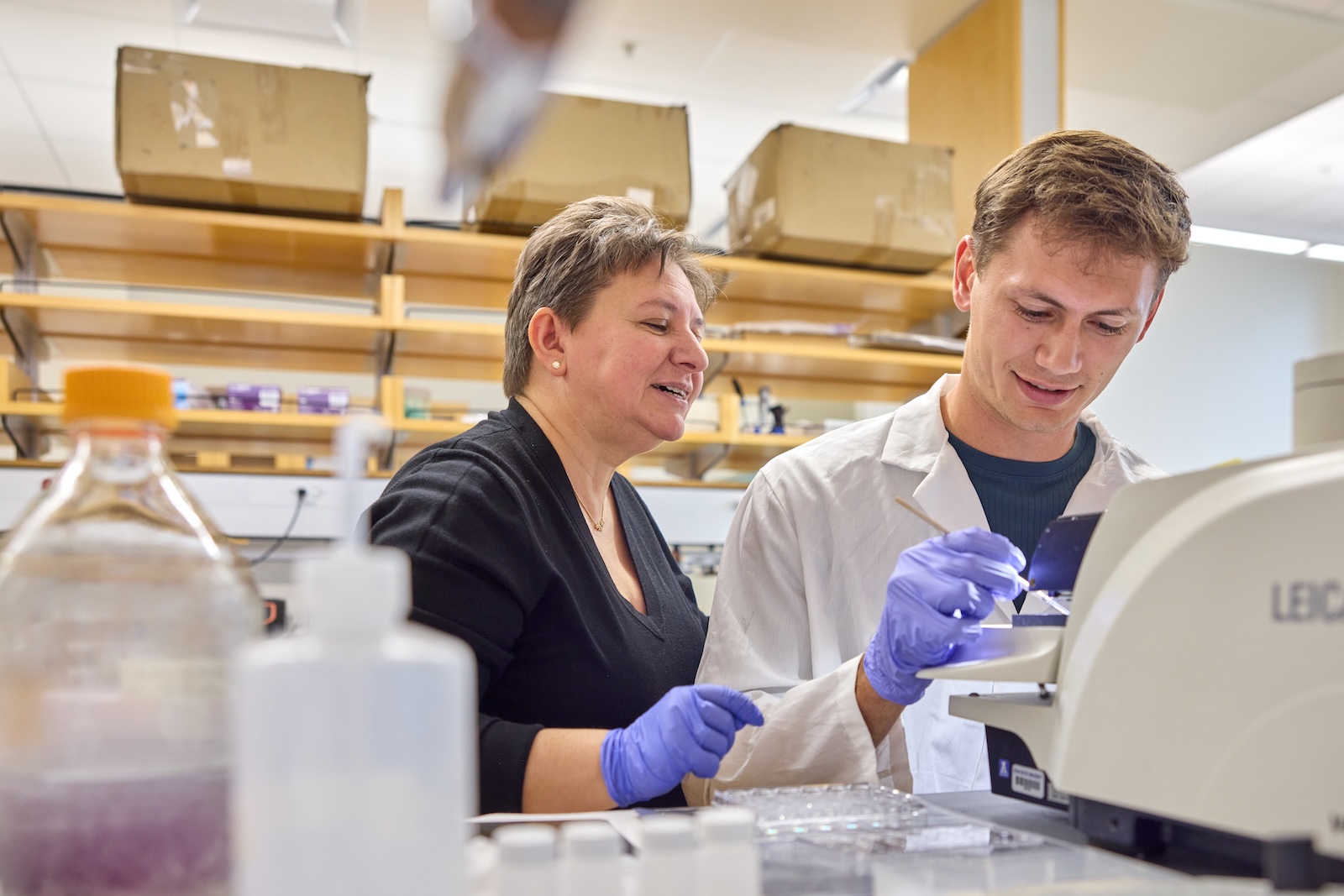Teacher instructing a student during a lab experiment