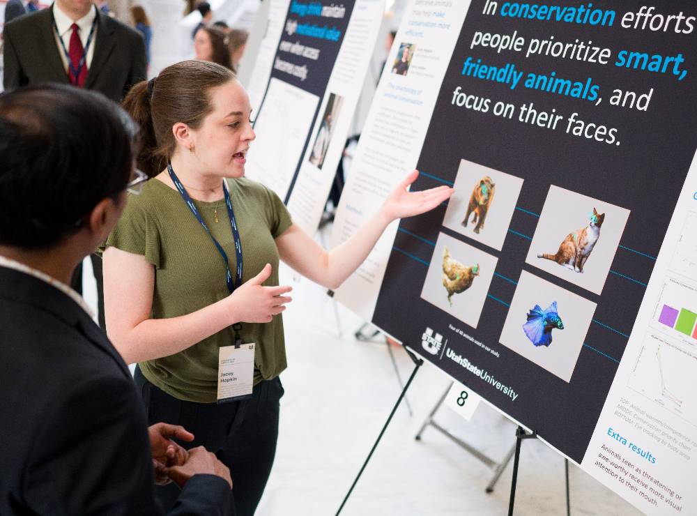 A student explaining her research to a visitor.