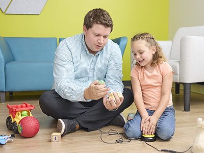 A clinician working with a kid and her toys.