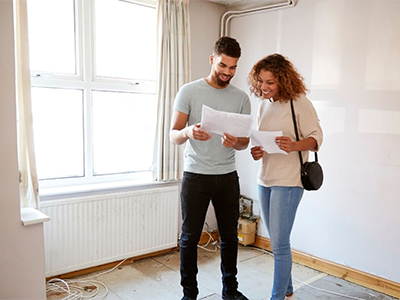 A couple looking at papers in a house in development.