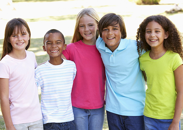 5 kids posing for a group photo.